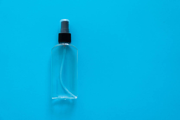 Bottle of antiseptic, a bottle of hand sanitizer, hand sanitizer spray on a blue background, for the prevention of coronavirus. Bottle of antiseptic spray mockup, copy space for design. - Fotografie, Obrázek