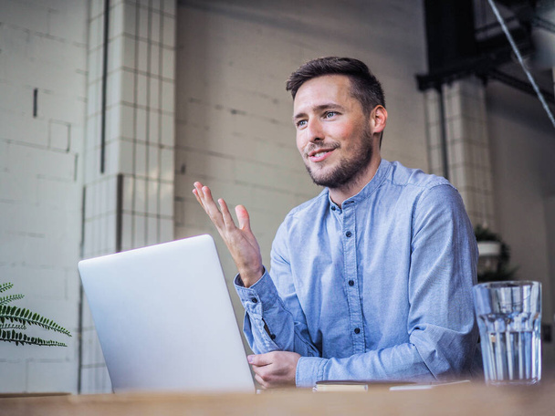 Mann in blauem Hemd mit Laptop in Coworking-Büro, Online-Fernarbeit und Quarantäne-Büro - Foto, Bild