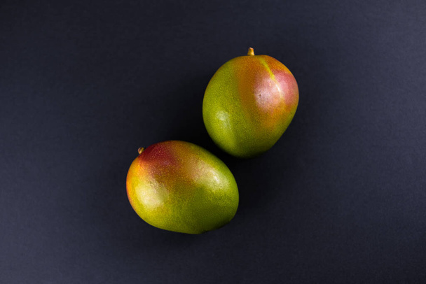 Tumma tausta kirkas trooppinen mango
 .  - Valokuva, kuva