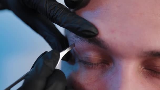 Augenbrauen zupft ein Mann in einem Schönheitssalon. - Filmmaterial, Video