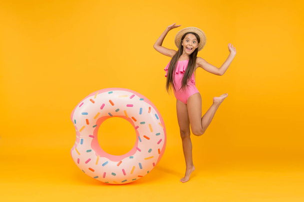 Getting golden tan. little girl going to play in water. having fun on the beach. happy kid on summer beach. Relax in Sea. having fun in waterpark. Girl with inflatable rubber ring at swimming pool - Фото, зображення