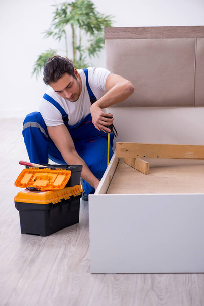 Fiatal férfi vállalkozó telepítése bútorok otthon - Fotó, kép