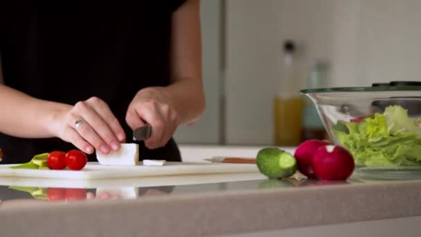 Woman cutting cheese in kitchen - Filmmaterial, Video