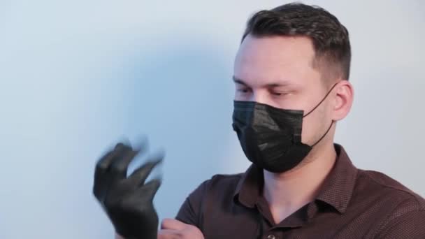 Young man puts rubber gloves on his hands. - Filmati, video