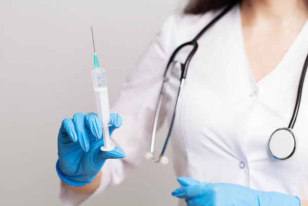 Une femme médecin portant des gants tient une seringue avec un vaccin
 - Photo, image