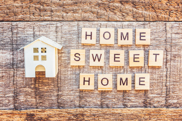 Pysy kotona. Pysy turvassa. Miniatyyri lelutalo kirjoitus HOME SWEET HOME kirjaimet sana puinen tausta. Yhteiskunnallinen etätietoisuus. Makea koti COVID-19 Coronavirus karanteeni käsite
 - Valokuva, kuva