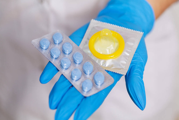 Női orvos kesztyűben tartja tabletták a férfiak szexuális egészség - Fotó, kép