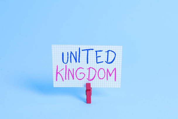Conceptual hand writing showing United Kingdom. Business photo showcasing Island country located off the northwestern coast of Europe Colored clothespin rectangle shaped paper blue background. - Photo, Image