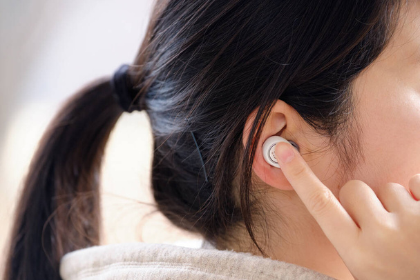 Profilo di una donna che indossa auricolari wireless nelle orecchie
 - Foto, immagini