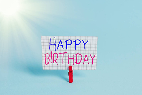 Fogalmi kézírás boldog születésnapot. Üzleti fotó bemutatása Az egyén születésének évfordulóját ajándékokkal ünneplik Színes ruhaszárító téglalap alakú papír kék háttér. - Fotó, kép