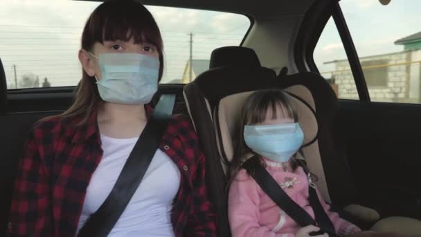 Egészséges fiatal nő védekező steril orvosi maszkban autót vezet. a pandémiás koronavírus fogalma. A szabad lány maszkban utazik egy autóban. vírusok és baktériumok elleni védelem. Egy lány autózik. - Felvétel, videó