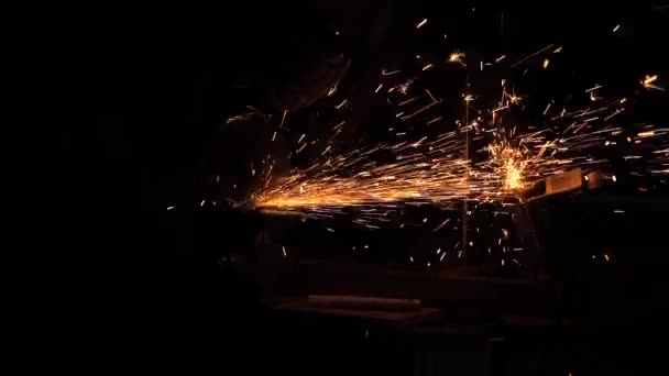 工場で金属加工してる。スローモーション。工場で働く労働者は金属を加工して火花を散らします。男は征服者に取り組んでいる. - 映像、動画