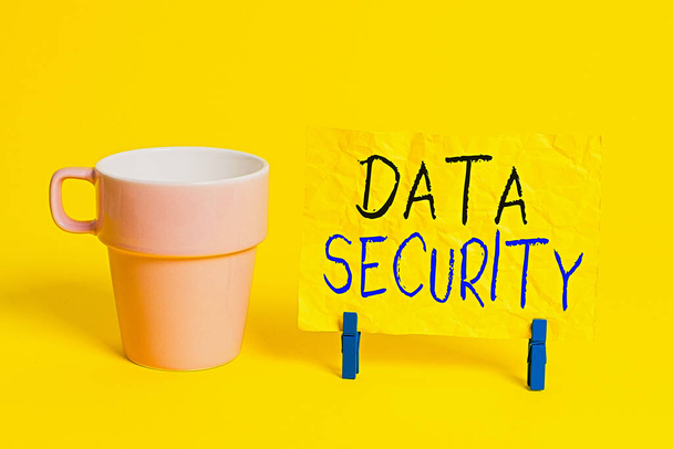 Conceptual hand writing showing Data Security. Business photo showcasing Confidentiality Disk Encryption Backups Password Shielding Paper blue clothespin rectangle shape reminder yellow office. - Photo, Image