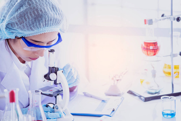 Naispuolinen tiedemies katso mikroskooppi, tiede koeputki analysoida tieteellisen näytteen laboratoriokokeessa biotekniikka tehdä viljellä rokote virusta vastaan. Kemian tieteen laboratoriokonsepti - Valokuva, kuva