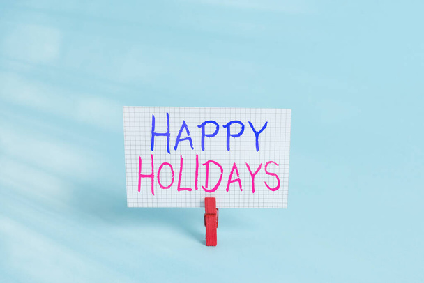 幸せな休日を示す概念的な手の書き込み。展示会のビジネス写真喜びを示すグループによって短い旅をした色の布の四角形の形の紙青の背景. - 写真・画像