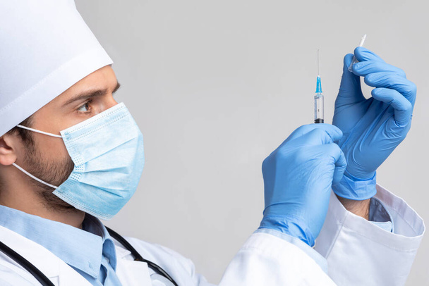 Professionele arts die de spuit met vaccin klaarmaakt, close-up - Foto, afbeelding