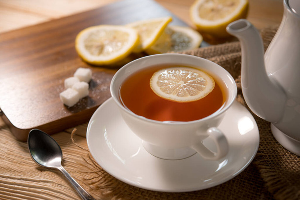 egy csésze tea citrommal a fa asztalon - Fotó, kép