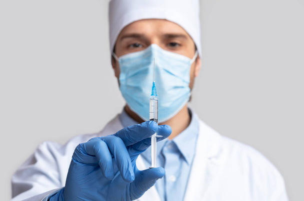 Arzt hält Spritze mit Impfstoff zur Injektion bereit - Foto, Bild