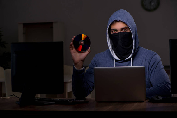 Male hacker hacking security firewall late in office - Photo, Image