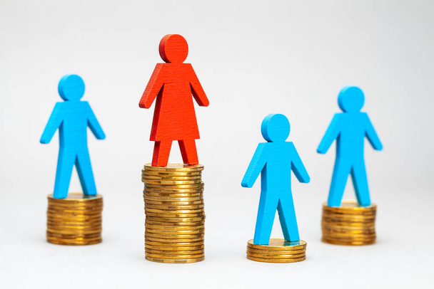 Discriminatie van mannen op het werk. Het salaris van vrouwen is hoger dan dat van mannen. Stapel moent en cijfers van mannen en vrouwen - Foto, afbeelding