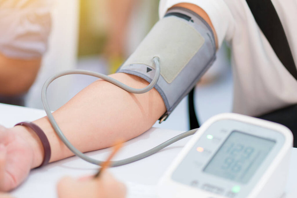 病院で患者の動脈血圧をチェックする医師.ヘルスケアの概念. - 写真・画像
