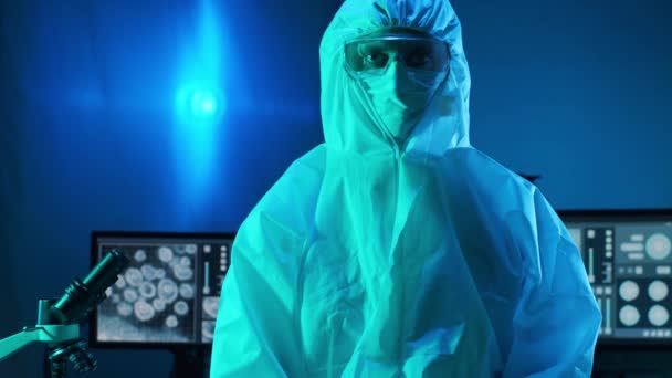 Scientist in protection suit and masks working in research lab using laboratory equipment: microscopes, test tubes. Coronavirus 2019-ncov hazard, pharmaceutical discovery, bacteriology and virology - Footage, Video