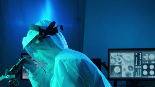 Вчений у захисному костюмі та масках, що працюють у науково-дослідній лабораторії, використовує лабораторне обладнання: мікроскопи, пробірки. Коронавірус 2019-московська небезпека, фармацевтичні відкриття, бактеріологія та вірусологія
 - Кадри, відео