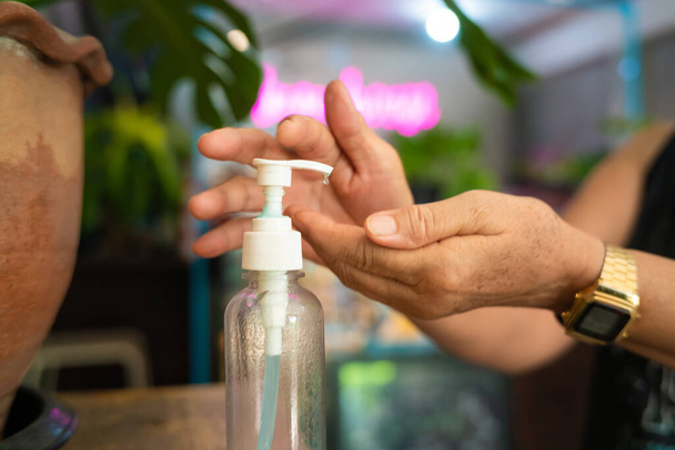 Le donne asiatiche mano utilizzando alcol gel antisettico lavamani prevenire contro l'infezione del focolaio di Covid-19, donna che lava le mani con disinfettante per le mani all'aperto - Foto, immagini