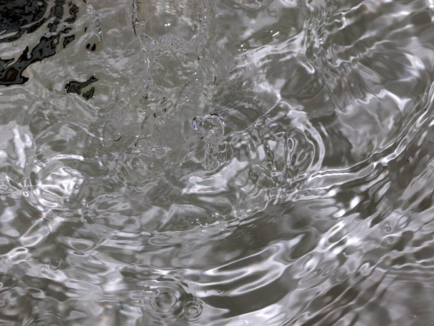 splashes and waves on the surface a rapid flow of clean boiling water - Foto, afbeelding
