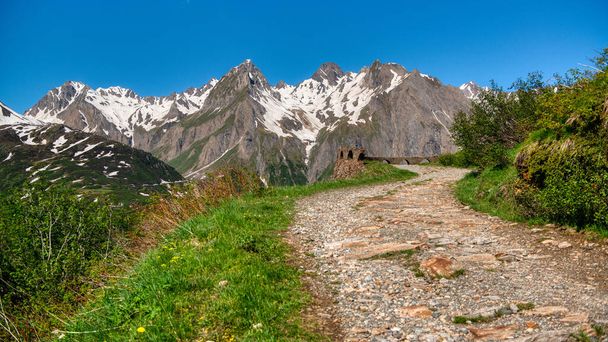 Mountain path with snowy peak in background, Formazza valley in summer season - Photo, Image