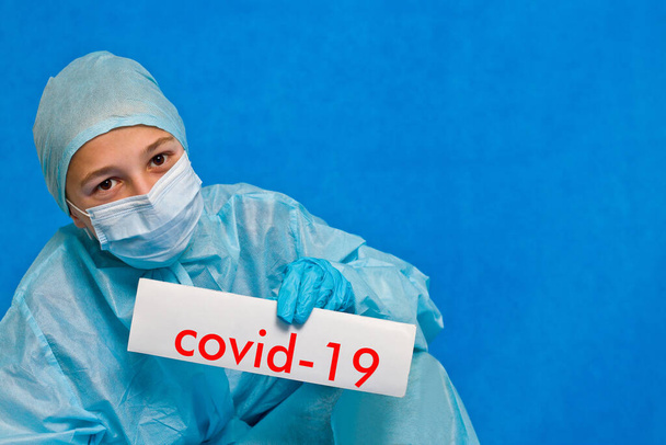 Jovem médico mostrando um sinal dizendo covid-19
. - Foto, Imagem