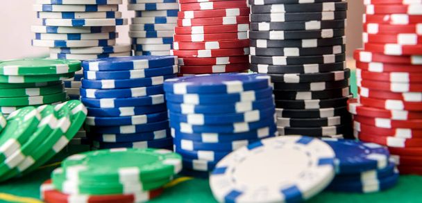 Szerencsejáték téma. Színes játék zseton halom zöld asztal közeli - Fotó, kép