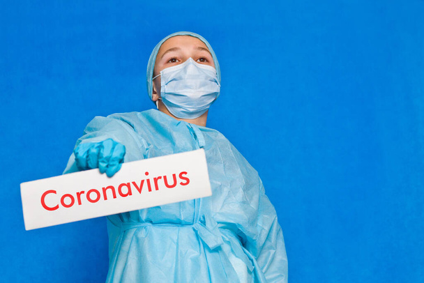 Молодой доктор показывает знак "коронавирус"
. - Фото, изображение