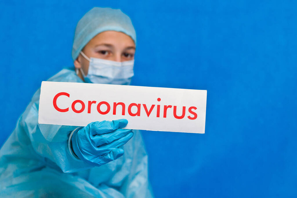 Jonge dokter toont een teken dat zegt coronavirus. - Foto, afbeelding
