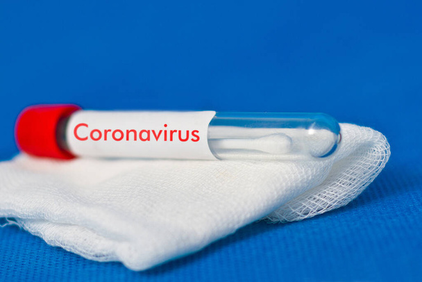 Reagenzglas auf Gaze. Analyse auf Coronavirus markiertes Coronavirus - Foto, Bild