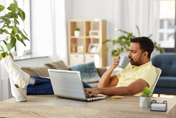 man with laptop drinking coffee at home office - Φωτογραφία, εικόνα