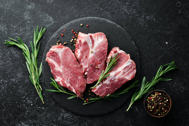 Raw meat steaks with rosemary and spices. Top view. Free space for your text. - Фото, изображение