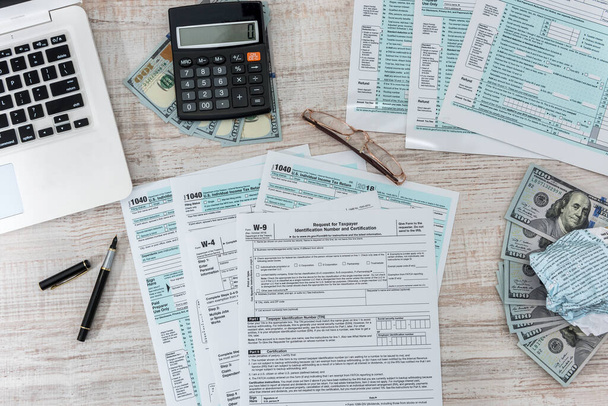 1040 tax form on desk with pen calculator and us dollar. business concept. - 写真・画像