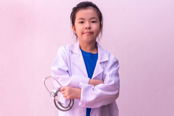 Азиатка играет в доктора со стетоскопом в руках
.  - Фото, изображение