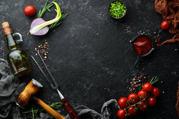 Black cooking background. Rosemary and spices on a black stone table. Top view. Free space for your text. - Foto, afbeelding