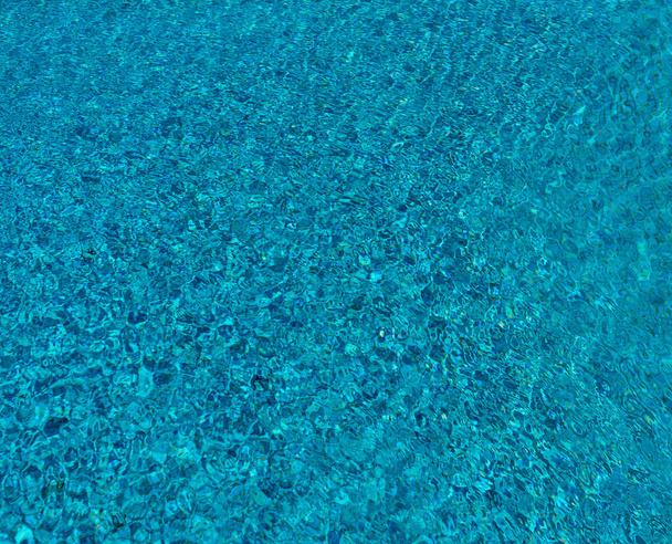 Agua azul y transparente de la piscina, movida por la brisa del viento
 - Foto, Imagen