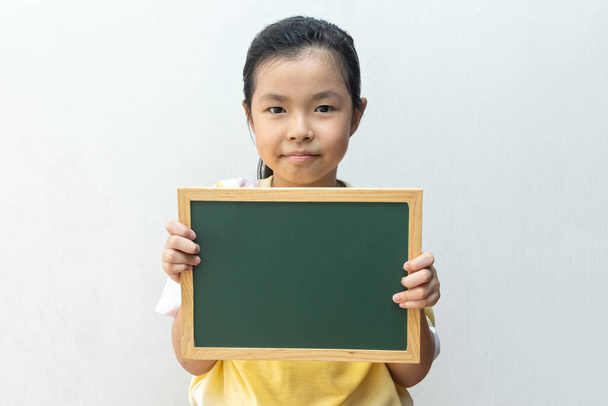 Menina asiática segurando placa vazia. Conceito de educação
 - Foto, Imagem