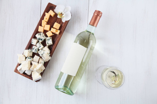 Bottiglia di vino, formaggio e un bicchiere su sfondo in legno vista dall'alto
 - Foto, immagini