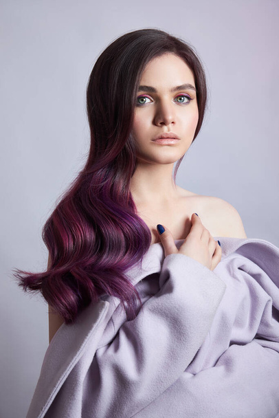 Portrait of a woman with bright colored flying hair, all shades of purple. Shiny Healthy colored Hair coloring, beautiful lips and makeup. Sexy girl with long hair styling - Photo, Image