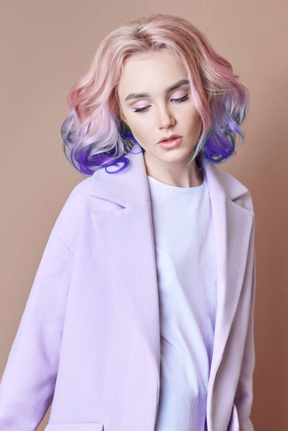 Portrait of a woman with bright colored flying hair, all shades of purple. Hair coloring, beautiful lips and makeup. Hair fluttering in the wind. Sexy girl with short  hair. Professional coloring - Foto, immagini