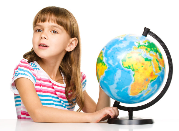 Little girl is examining globe - Fotoğraf, Görsel