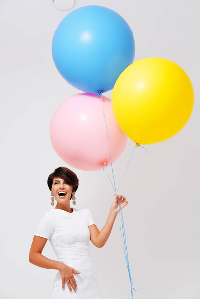 portrait laughing woman with bunch of colorful balloons  - Photo, Image