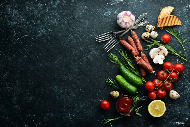 Set of healthy food: tomatoes, pasta, spices, vegetables and sausages. Top view. Black stone background. - Photo, image