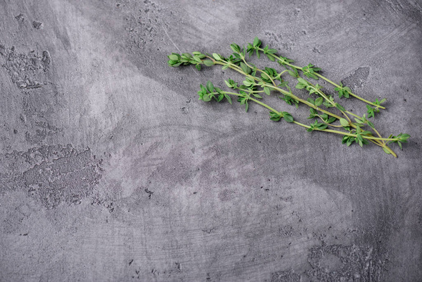 Fresh sprigs of thyme on a gray concrete background, top view - Valokuva, kuva