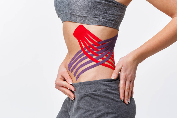 Weight loss concept. Kinesiology taping.Anti-cellulite procedure for slim belly.Close up view of kinesiology tape on patient tummy.Fat lose, cellulite removal, sport physical therapy,recovery concept - Foto, Bild